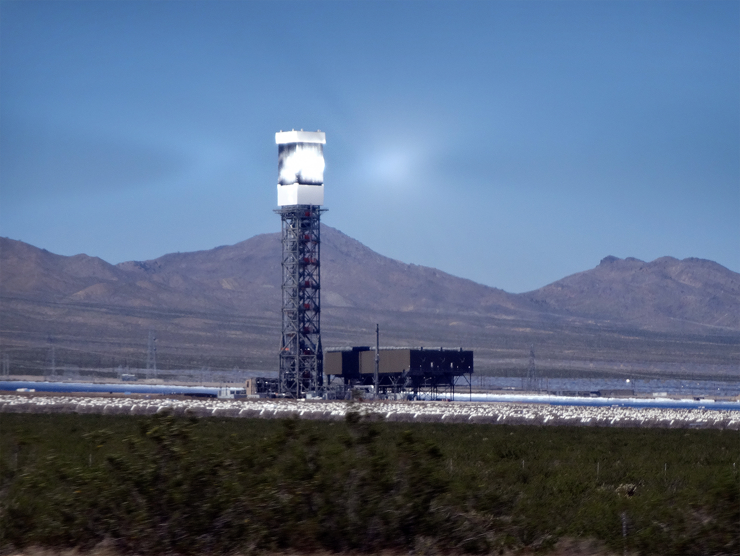 The Ivanpah solar power towers in the Mojave Desert, with bright receiver towers and fields of mirrors.