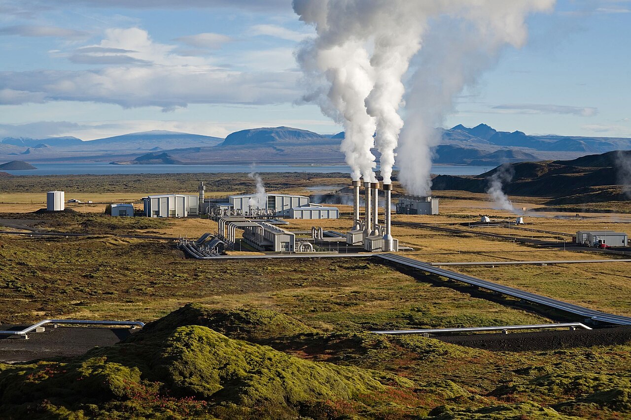 Nesjavellir geothermal power plant in Iceland, steam rising beside pipes and mountains.