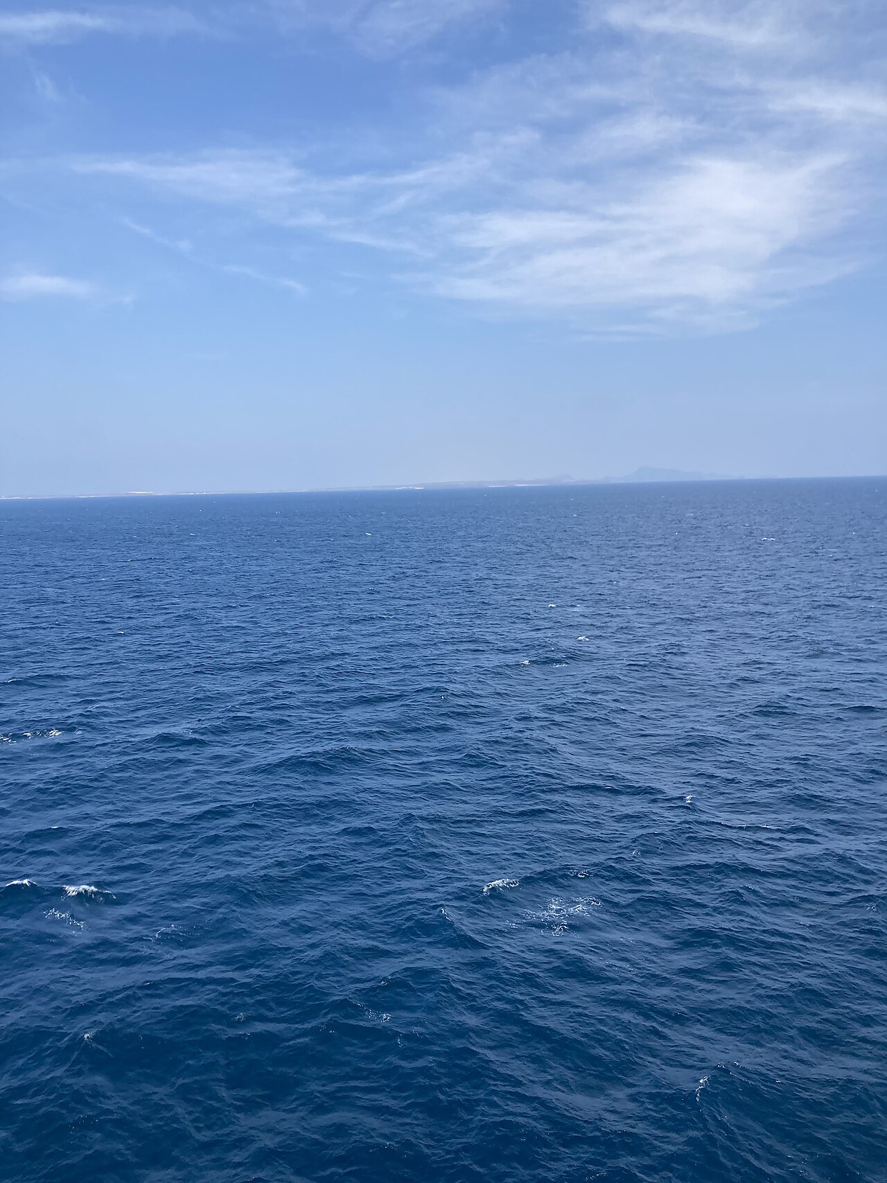 The Bab el-Mandeb strait seen from a ship mid-channel, with the Yemeni coast on the horizon.