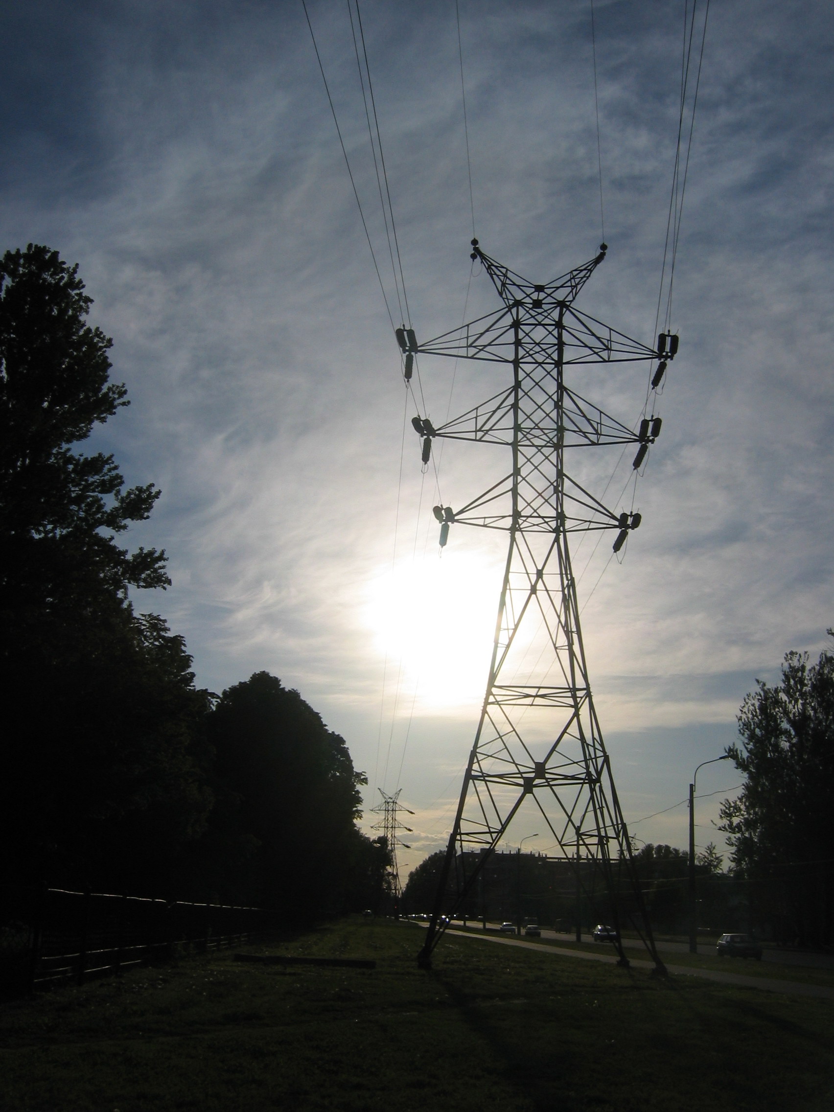 A high-voltage transmission pylon against a clear sky.